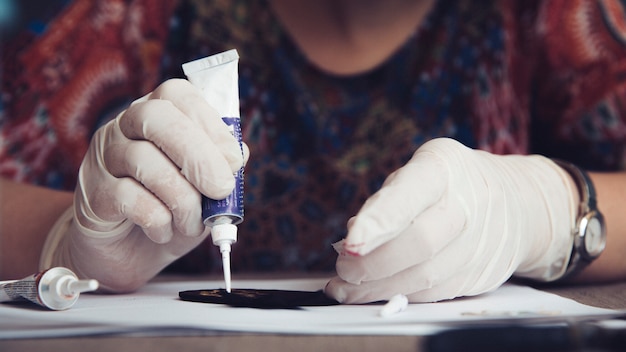 Meister, der mit Kleber am Handwerk arbeitet