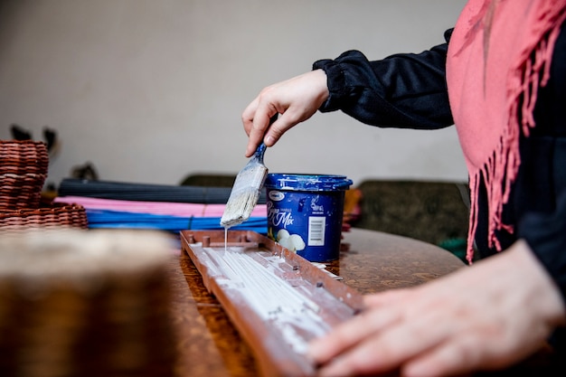 Meister malt ein Stück Holz im Atelier. Hochwertiges Foto