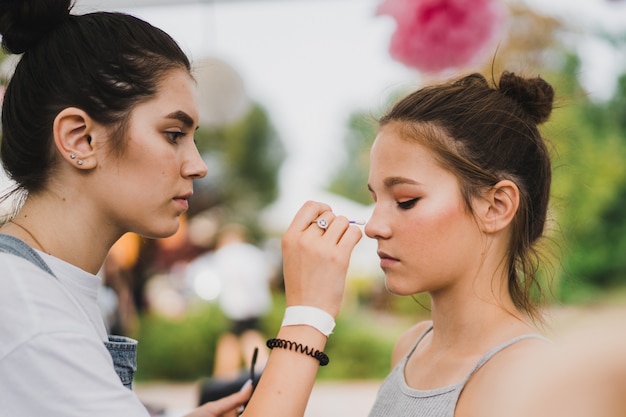 Meisterklasse Make-up. Mädchen macht Make-up zu ihrer Freundin