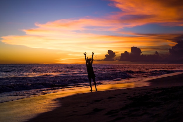 Menschen am Strand bei Sonnenuntergang. das Mädchen springt