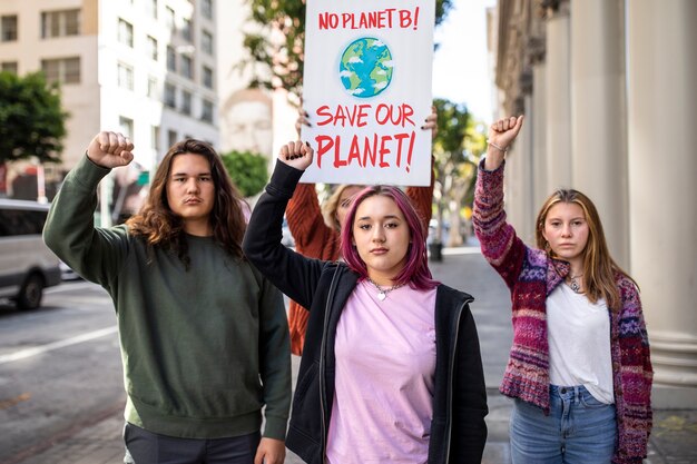 Menschen an einem Weltumwelttag protestieren im Freien mit Plakaten