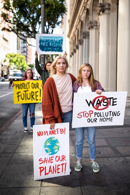 Kostenloses Foto menschen an einem weltumwelttag protestieren im freien mit plakaten