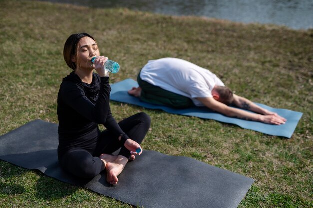 Menschen, die draußen Yoga praktizieren