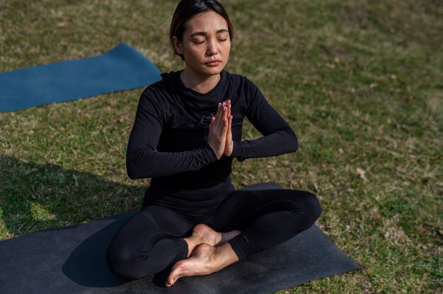 Menschen, die draußen Yoga praktizieren