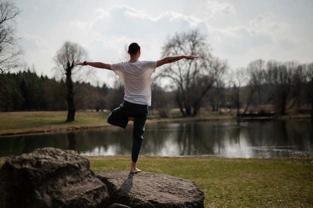 Menschen, die draußen Yoga praktizieren