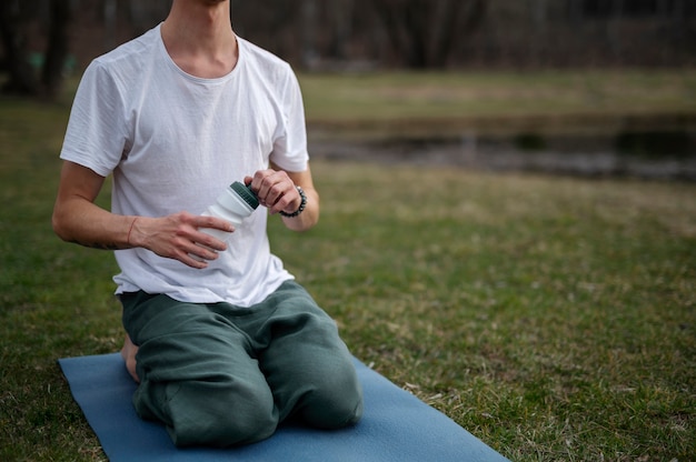 Kostenloses Foto menschen, die draußen yoga praktizieren