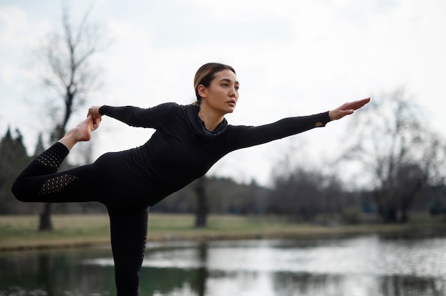 Kostenloses Foto menschen, die draußen yoga praktizieren