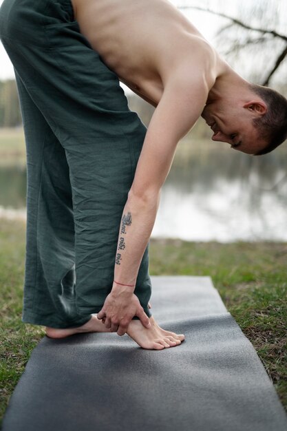 Menschen, die draußen Yoga praktizieren