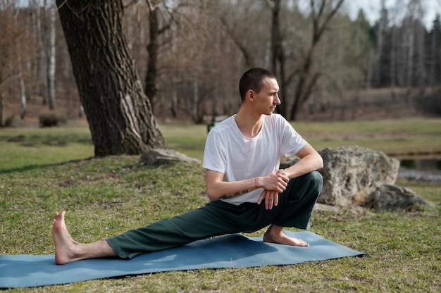 Kostenloses Foto menschen, die draußen yoga praktizieren