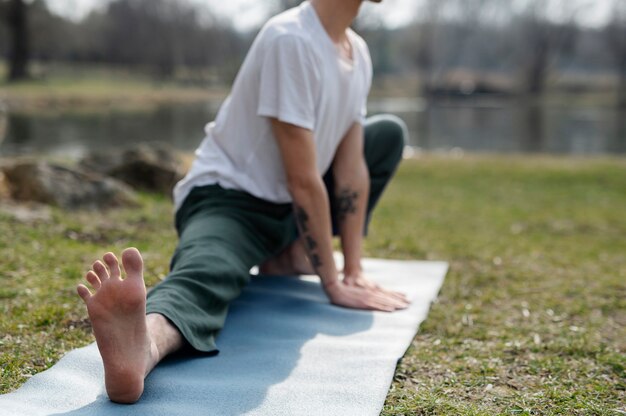 Kostenloses Foto menschen, die draußen yoga praktizieren