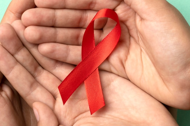 Menschen, die ein rotes Symbol zum Welt-Aids-Tag halten