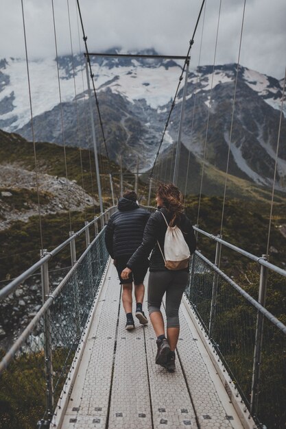 Menschen, die eine Brücke am Mount Cook in Neuseeland überqueren