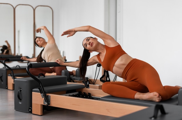 Kostenloses Foto menschen, die pilates-reformer-kurse besuchen