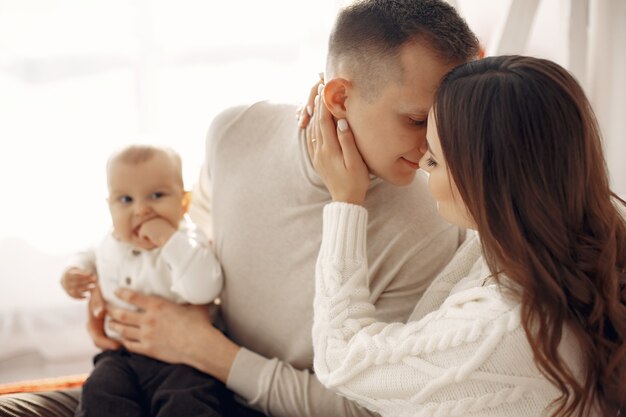 Menschen, die sich auf Weihnachten vorbereiten. Leute, die auf einem Bett sitzen. Familie ruht in einem festlichen Raum.