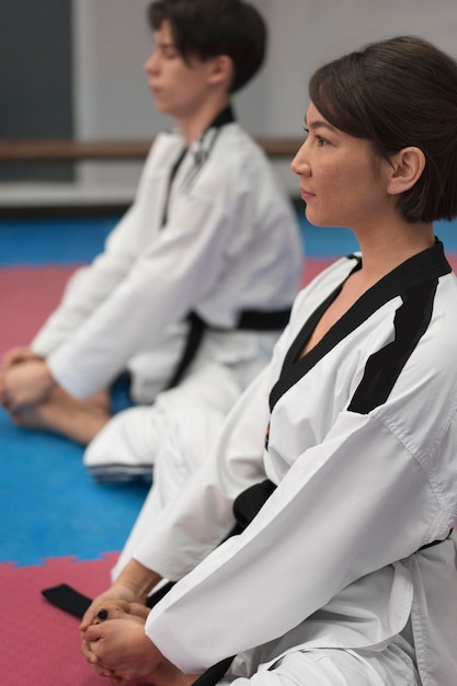 Menschen, die Taekwondo in einer Turnhalle praktizieren