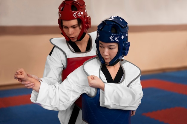 Kostenloses Foto menschen, die taekwondo in einer turnhalle praktizieren
