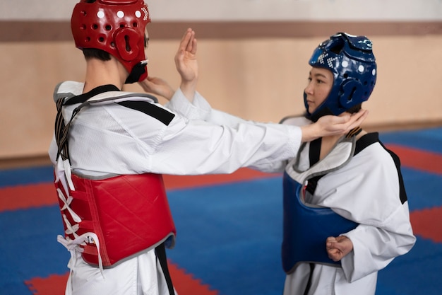 Kostenloses Foto menschen, die taekwondo in einer turnhalle praktizieren