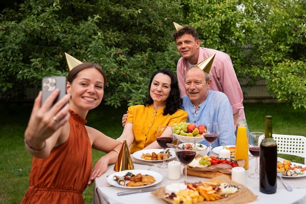 Menschen feiern eine Senior-Geburtstagsfeier im Freien im Garten