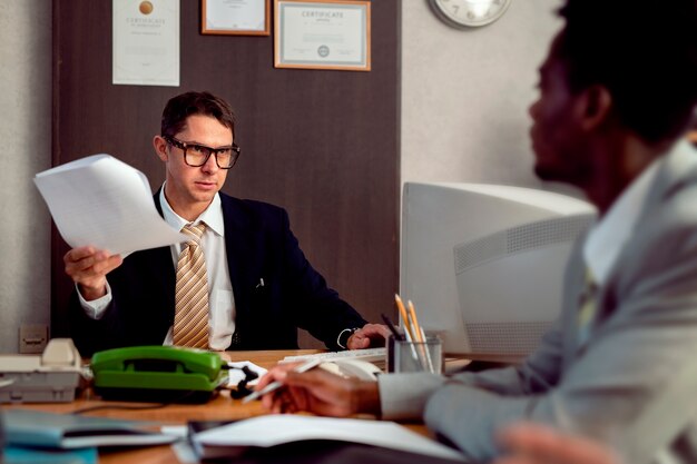 Menschen im Vintage-Stil, die in einem Büro mit Computern arbeiten