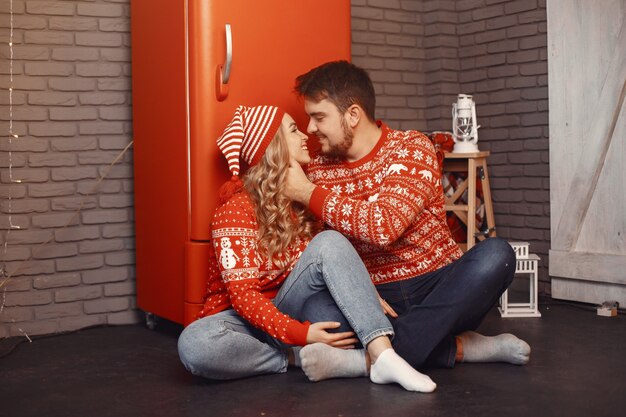 Menschen in einer Weihnachtsdekoration. Mann und Frau in einem roten Pullover.