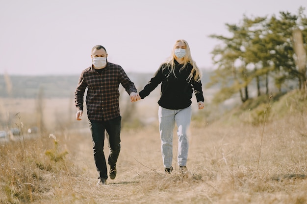 Menschen in Masken gehen auf einem Feld