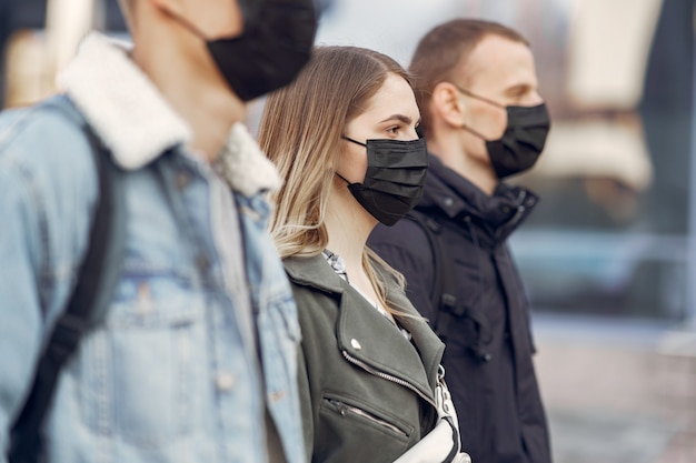 Menschen in Masken stehen auf der Straße