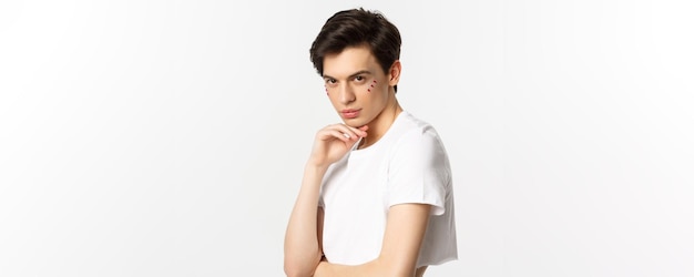 Menschen lgbtq und Schönheitskonzept Schönes androgynes männliches Modell mit Glitzer im Gesicht mit Ernte t