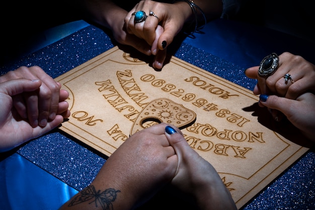 Menschen mit hohem Winkel, die gemeinsam Ouija-Brett verwenden