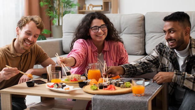 Menschen mit Vorderansicht, die zu Hause Sushi essen