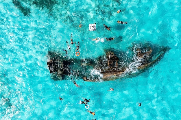 Menschen schnorcheln um das schiffswrack in der nähe von cancun im karibischen meer. schönes türkisfarbenes wasser mit menschen, die mit fischen schwimmen, luftbild.