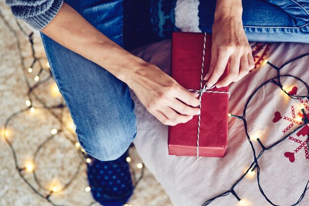 Menschliche Hand, die eine Schnur an einem Geschenk bindet