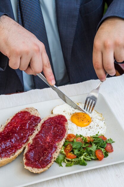 Menschliche Hand, die Frühstück in der Gaststätte isst