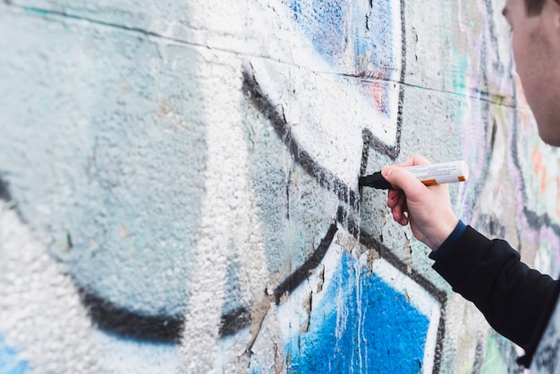 Menschliche Hand, die Graffiti mit Markierung zeichnet