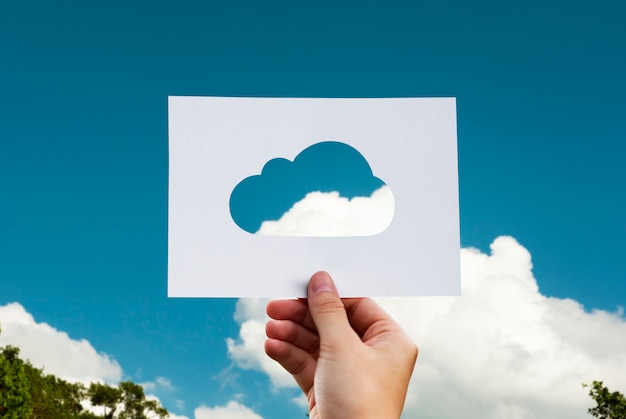 Kostenloses Foto menschliche hand, die wolke perforiertes papierhandwerk in der natur hält