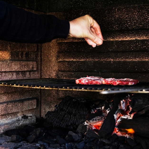 Menschliche Handgewürzfleisch auf Grillgrill