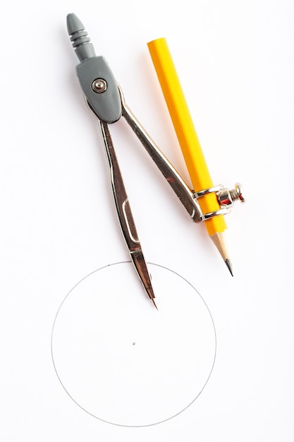 Metallischer Kompass isolierte eine Draufsicht mit Bleistift auf weißem Schreibtisch