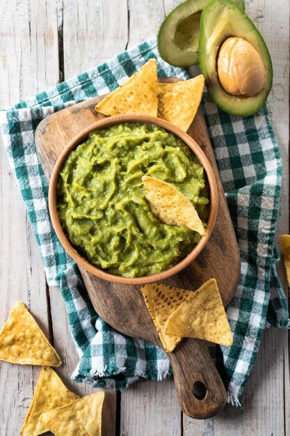 Mexikanische Guacamole mit Nacho-Chip in Holzschale