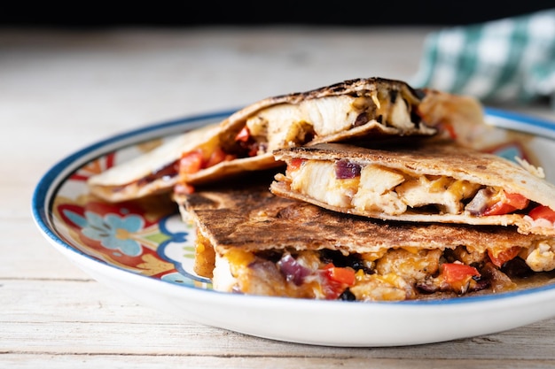 Kostenloses Foto mexikanische hühnchen-quesadillas mit käse und paprika auf einem holztisch.