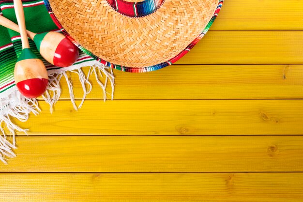 Mexikanische Hut und Maraca über gelb Boden
