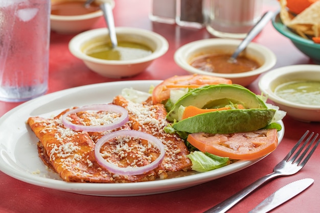 Mexikanische leckere gebratene Eierbrötchen mit Salat-Avocado-Zwiebeln und Tomaten