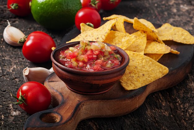 Mexikanische Nacho-Chips und Salsa tauchen in eine Schüssel