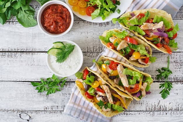 Mexikanische Tacos mit Hühnchen, Paprika, schwarzen Bohnen und frischem Gemüse