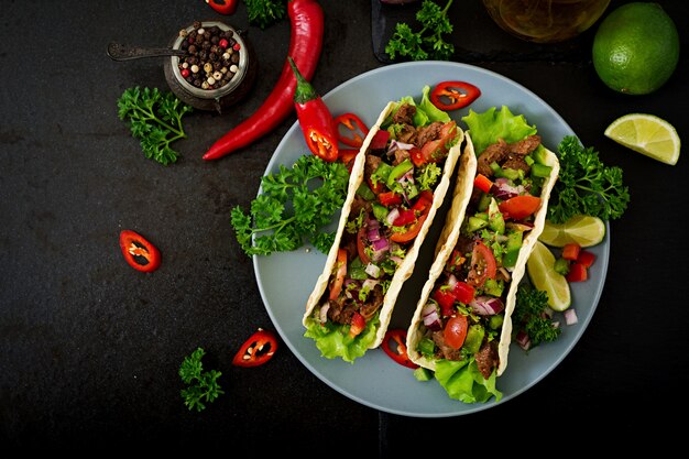 Mexikanische Tacos mit Rindfleisch in Tomatensauce und Salsa