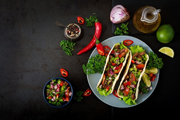 Mexikanische Tacos mit Rindfleisch in Tomatensauce und Salsa