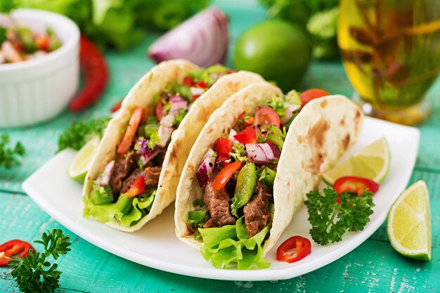 Mexikanische Tacos mit Rindfleisch in Tomatensauce und Salsa