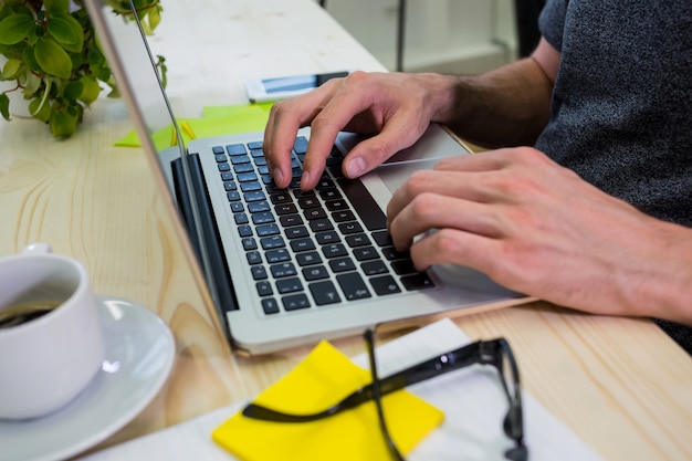 Kostenloses Foto mid-abschnitt der männlichen unternehmensleiter mit laptop