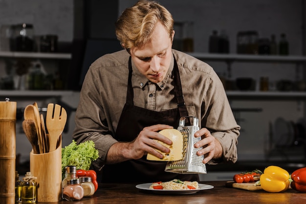 Mid Shot Chef, der Käse reibt