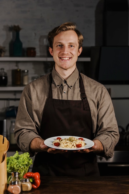 Mid Shot Chef hält Teller mit Nudeln