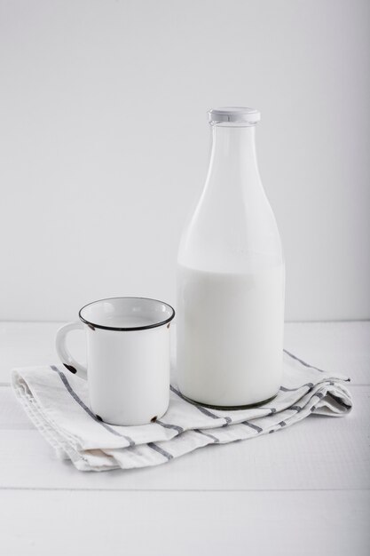 Milch in der Flasche in der Nähe von Tasse