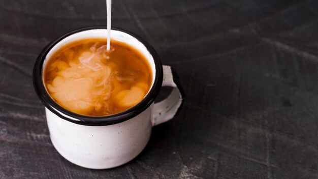 Milch in schwarzen Kaffee gegossen